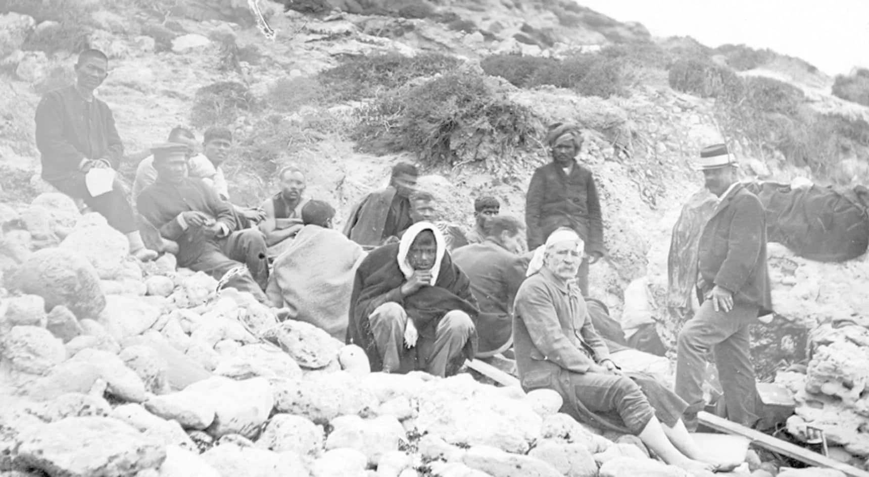Surviving members of SS Clan Ranald crew photographed on rocky ground following the 1909 disaster