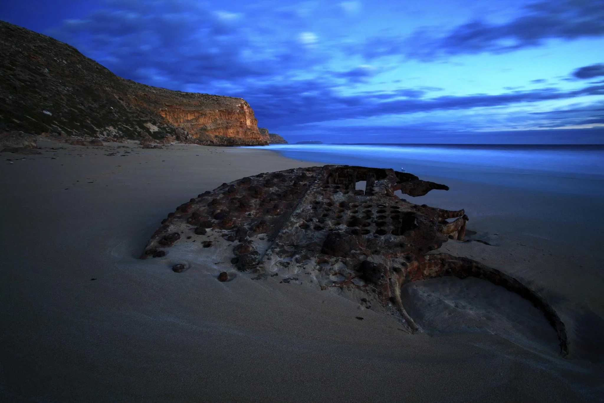 Exposed rusted ribs of Ethel wreck in the sand