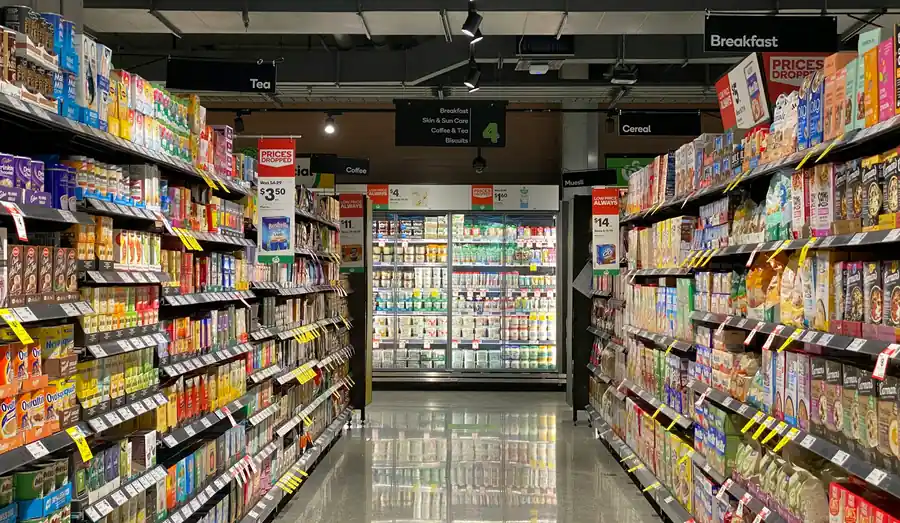 Supermarket aisle stocked with groceries and everyday food