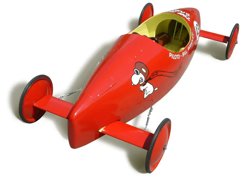 Soap box derby racer with a low body, exposed wheels and simple running gear